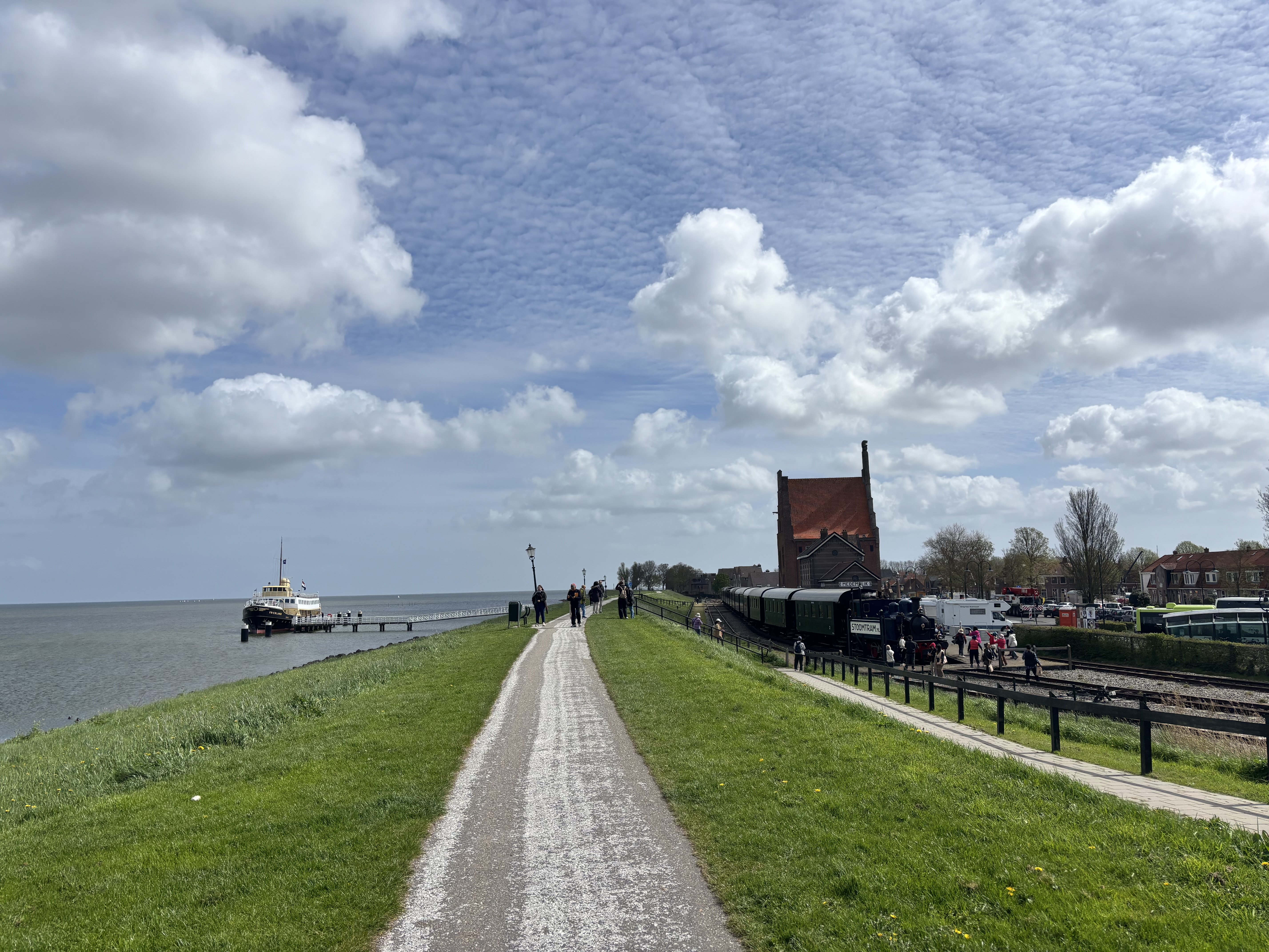 Walking the dyke path: a passenger ferry moored on the IJsselmeer to the left, the old steam pumping station and our waiting train to the right.