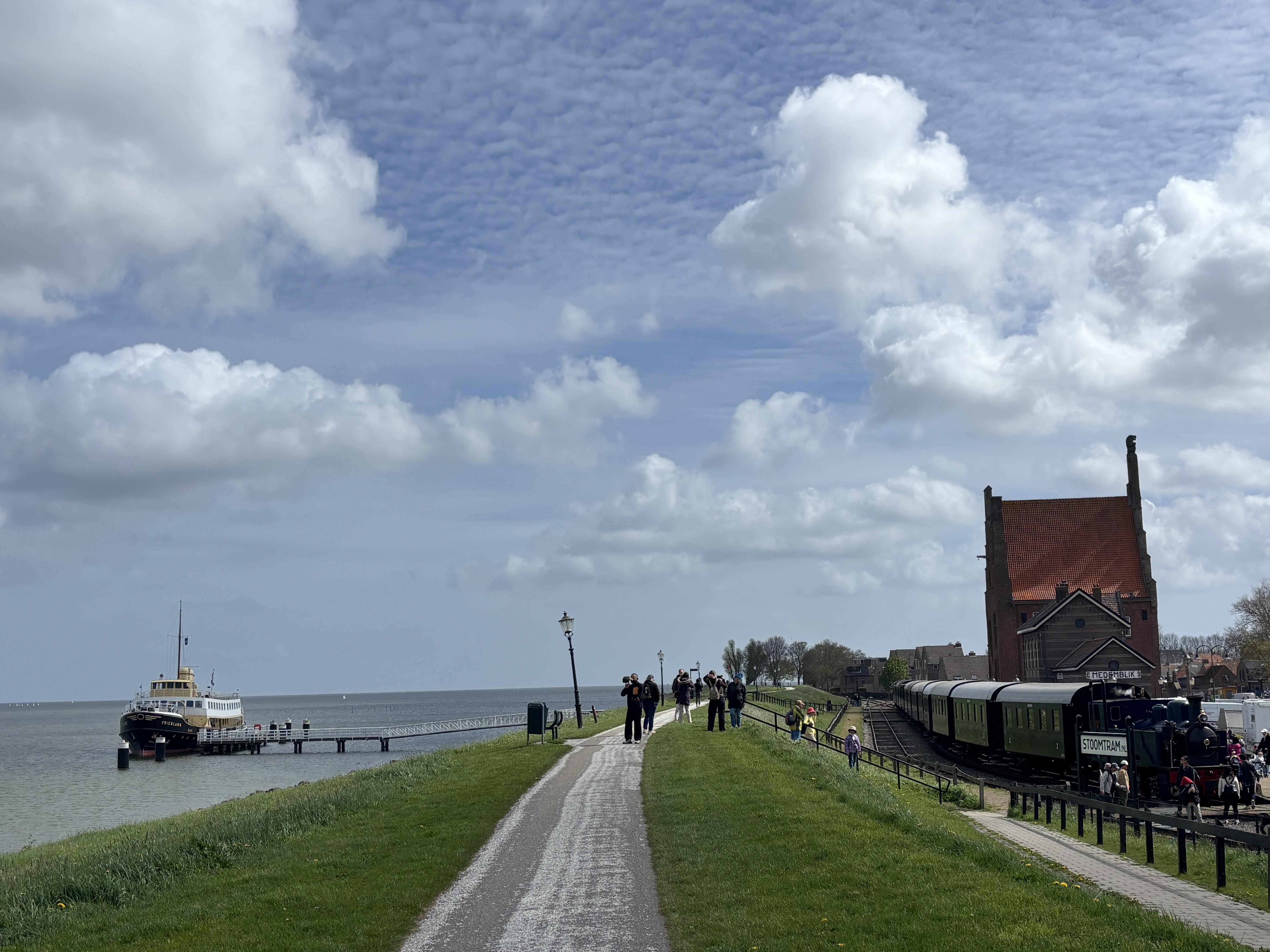 The same view a few minutes on — passengers boarding the steam train while the ferry prepares to depart across the inland sea.